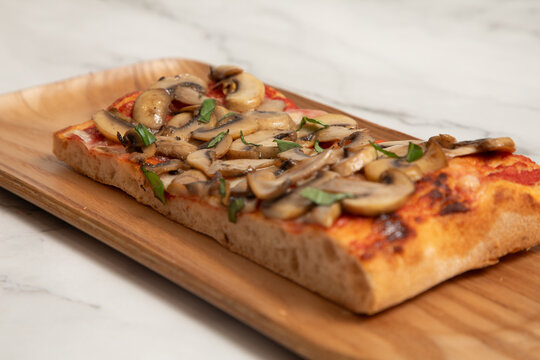 Pizza rectangulaire avec des champignons sur une table en bois