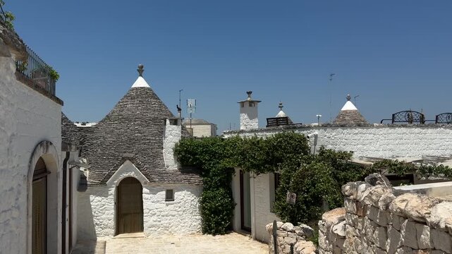 Authentic trullo house with whitewashed stone walls and iconic conical roof stands in a quiet courtyard of Alberobello. UNESCO heritage architecture, Italian culture, historic travel destination, sout