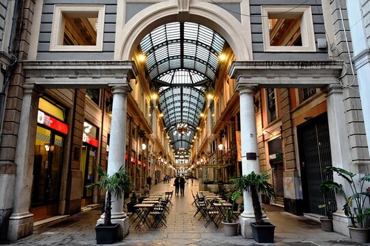 interior of vintage, antique style shopping mall in Genoa, Italy. shiny terrazzo and ceramic mosaic floor. arches, columns, windows and stucco elevation. arched glass skylight. travel and tourism.