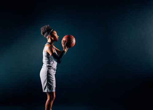Side view of a basketball player preparing to shoot a ball