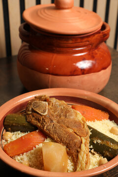 Cuisiner du couscous avec des morceaux de viande et des l&eacute;gumes dans un plat traditionnel