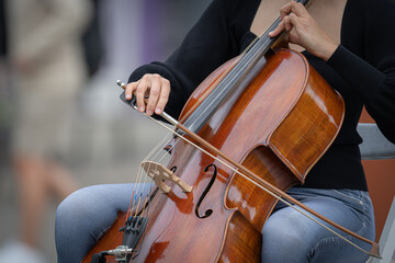 young musician playing cello on street © MARIS