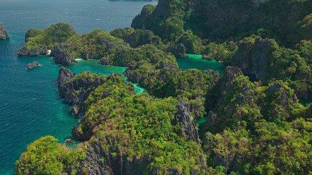 High Altitude Aerial View From Sea Flying Over Small and Big Lagoon in El Nido, Philippines. Drone Forward Flight Over Miniloc Island Limestone Cliffs and Deep Blue Ocean.