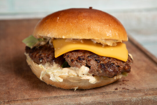 Savoureux hamburger avec fromage sur un plateau en bois