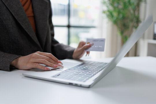 Customer shopping online with a credit card, buying products or services using an e-commerce platform on a laptop while processing payment and making a purchase