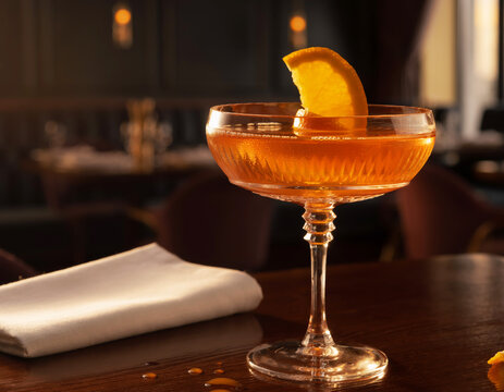 Elegant orange cocktail in a crystal coupe glass with an orange garnish