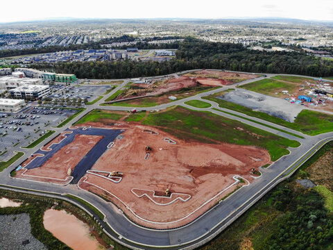 Ashburn, Virginia, United States - 17 October 2018: Aerial view of a construction site with cleared land, heavy machinery, and new roads, surrounded by suburban development.