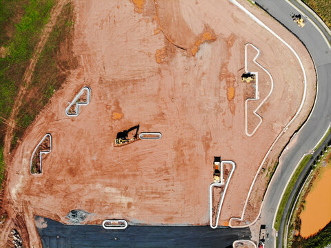 Ashburn, Virginia, United States - 17 October 2018: Aerial view of a construction site featuring red soil, heavy machinery, and concrete foundation forms.