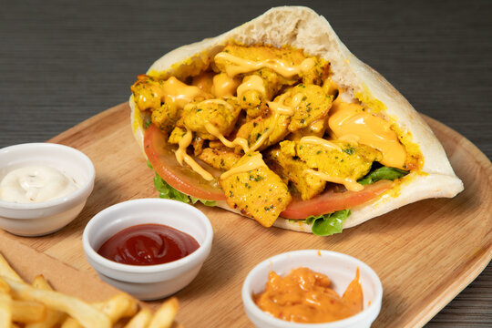Sandwich poulet curry avec sauce sur un plat en bois