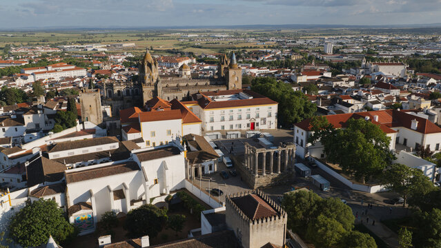 Evora, Portugal - 23 June 2026: Aerial view of the Roman Temple of Evora and the Cathedral of Evora surrounded by historic white buildings with terracotta rooftops.