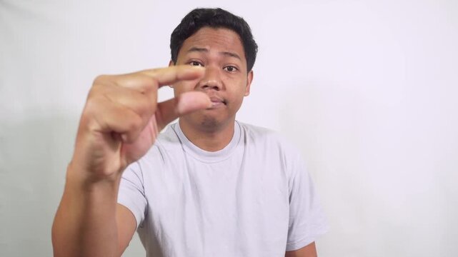 man holds a tiny object toward the camera in a clear close up shot