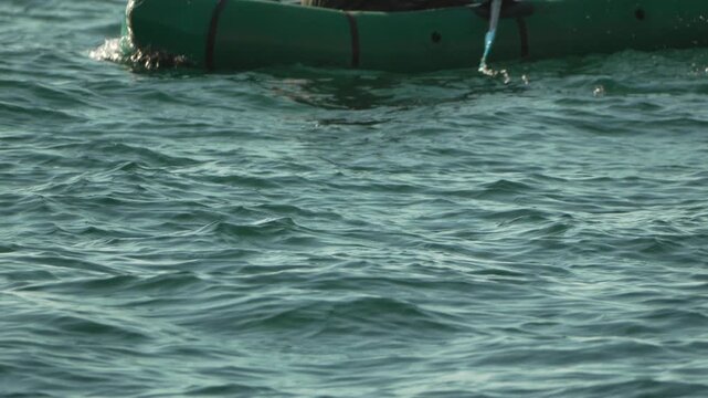 Paddling, inflatable, kayak man paddling an inflatable boat in choppy deep water during an outdoor adventure
