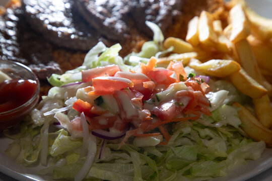 Plat de kefta servi avec des frites, salade et sauce dans un restaurant local