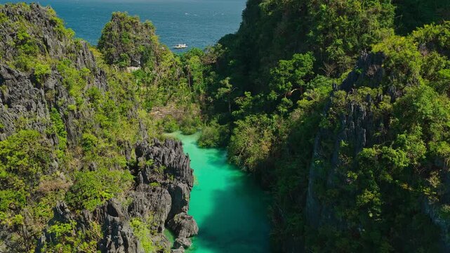 Aerial Backwards Reveal Shot from Dead End of Big Lagoon in El Nido, Philippines. Cinematic Drone Pull Away View Showcasing Turquoise Water and Lush Limestone Karst Cliffs.