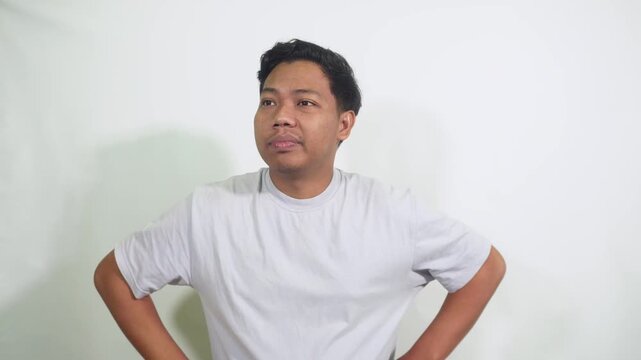 man covers his face with hand showing contemplation and mild embarrassment in a studio