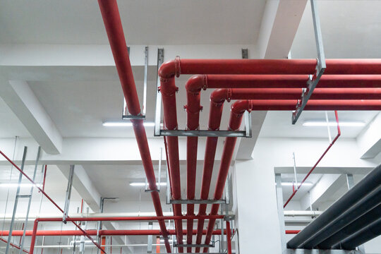 Red fire sprinkler pipes on ceiling of industrial building