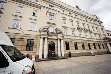 Naklejka premium Historic Poczta Polska post office facade with Polish flags, delivery van and classical columns in Lublin, Poland