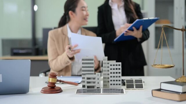 Business team consulting on real estate deal with building model, contract, and calculator. Ideal for property investment, legal agreement, and finance themes.