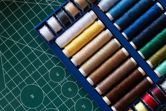 Sewing thread and bobbin thread spools in various colors on cutting cap