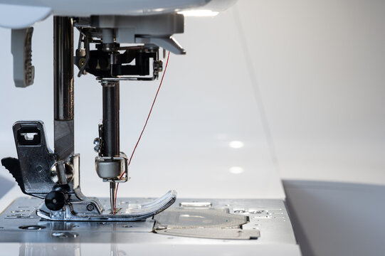 Sewing machine foot with needle at the bottom and carrier with view from the left side