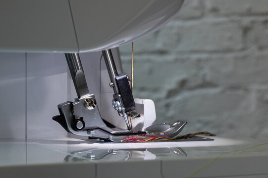 Overlock sewing machine foot with two needles at the bottom and carrier with view from the left side