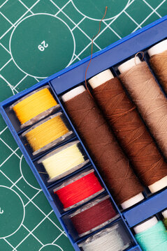 Sewing thread and bobbin thread spools in various colors on cutting cap