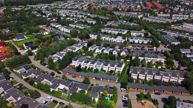 Suburban residential area townhouses drone view real estate housing development market. Aerial perspective showing rows of modern semi detached houses, private gardens and neighborhood infrastructure