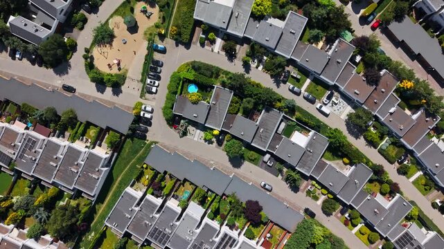 Drone view top down suburban residential housing estate townhouses real estate development property. Vertically oriented aerial perspective displaying modern semi detached houses with dark roofs