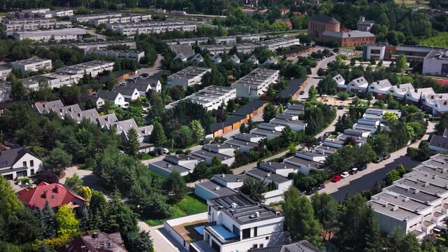 Drone view suburban residential housing estate newly built townhouses real estate property development. High angle aerial perspective of a modern neighborhood featuring contemporary family homes