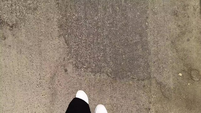 Close up of male legs in black shorts and white sneakers stepping forward on street