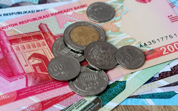 Uzbekistani som money bills and coins on table. Uzbekistan cash of UZS currency close up