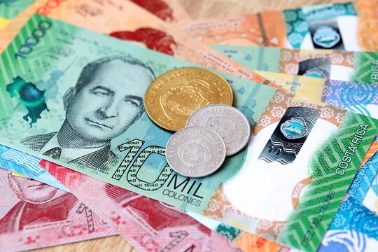 Costa Rican colon money bills and coins on table. Costa Rica cash of CRC currency close up