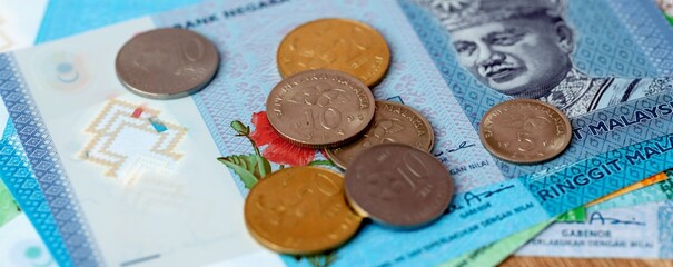 Malaysian ringgit money bills and coins on table. Malaysia cash of MYR currency close up © Larysa