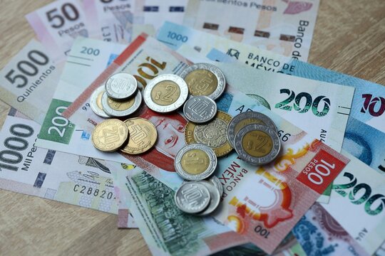 Mexican peso money bills and coins on table. Mexico cash of MXN currency close up