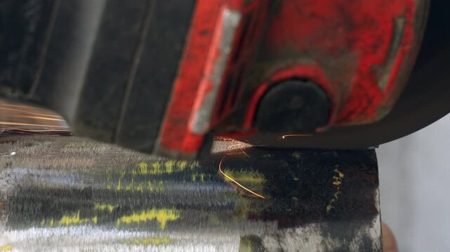 Macro shot of an abrasive grinding wheel on a steel tube surface before cutting