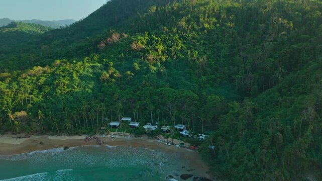 High Altitude Aerial View of Sea Turtle Release Event at Duli Beach in El Nido, Philippines. Drone Shot of Crowd Forming Guard of Honor on Golden Sand Shoreline for Hatchlings.