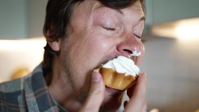 Sweet toothed man messily devouring a delicious cream cake with immense pleasure, highlighting the concepts of sugar addiction, overeating, and the potential risk of diabetes