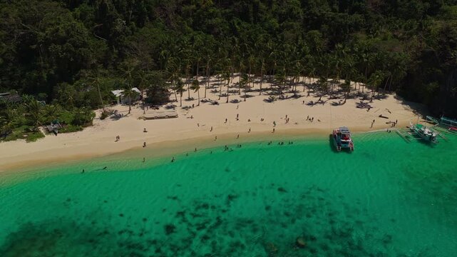 Aerial Orbit of Seven Commandos Beach From the Ocean in El Nido, Philippines. Cinematic Drone Left to Right Curved Tracking Shot of White Sand and Turquoise Shoreline.