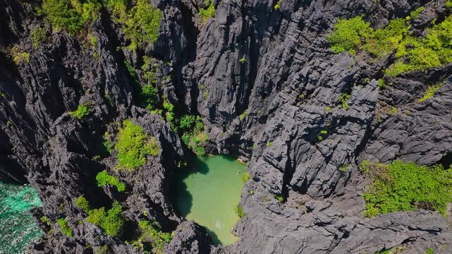 Aerial Forward Shot Flying Toward Secret Lagoon in El Nido, Philippines. Cinematic Drone Approach of Hidden Turquoise Water Enclosed by Dramatic Limestone Cliffs.
