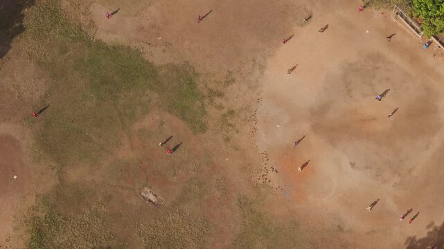 Aerial view of people playing baseball on a dirt diamond