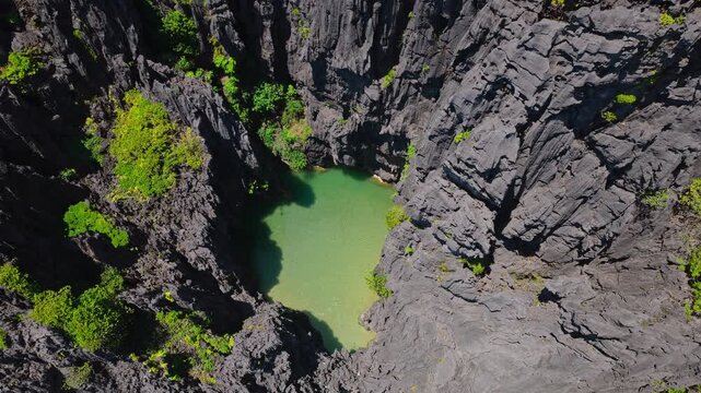 Aerial Descent Shot Into Secret Lagoon in El Nido, Philippines. Cinematic Drone Vertical Pedestal Down Over Turquoise Water Enclosed by Towering Limestone Cliffs.