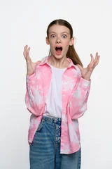 Shocked teenage girl with wide eyes and open mouth expressing surprise, amazement and disbelief. Studio portrait on light background. © o_lypa