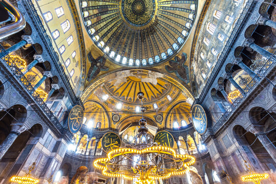 Interior view of Hagia Sophia Mosque with visitors beneath its historic dome in Istanbul, Turkey