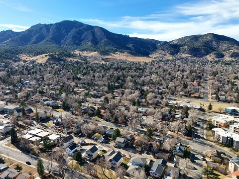 Boulder, Colorado, USA - 26 December 2025: Aerial view of the Flatirons rising above residential neighborhoods and tree-lined streets in Boulder, Colorado.