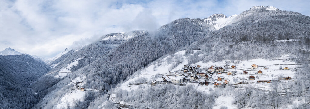 La Lechere, Auvergne-Rhone-Alpes, France - 15 March 2026: Aerial view of Bonneval village nestled in the snow-covered French Alps, with traditional houses and dense pine forests.
