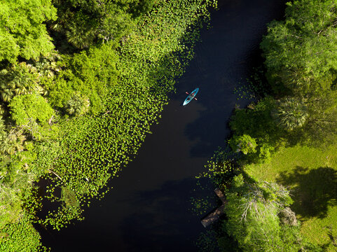 Aerial top down view of a lone kayaker paddling down Wekiva River near Wekiwa Springs in Longwood, Florida, USA.  April 20, 2022. 