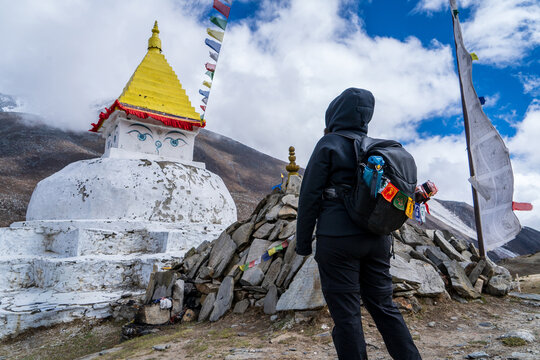 Mujer mirando estupa y banderitas de colores budistas, en la regi&oacute;n del valle de khumbu. Camino al Everest Base Camp.	