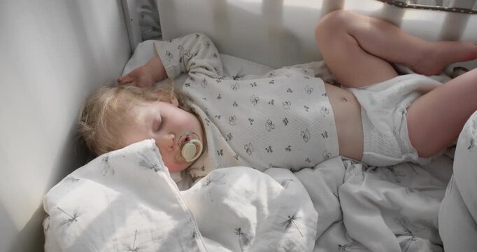 Sleeping toddler resting peacefully in nursery bed. Child sleep schedule and healthy development concept