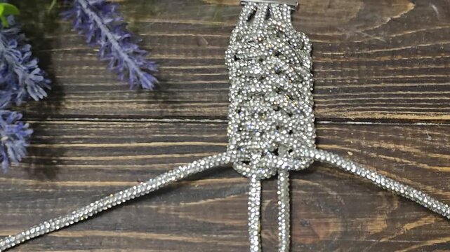 A bracelet made of shiny cords on a dark background. Women's jewelry. Handmade.