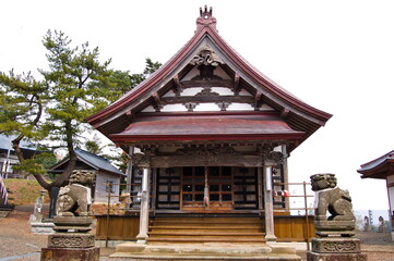 Obraz premium Traditional main hall of Gikeiji Temple with stone Komainu guardian statues in Sotogahama Aomori Japan